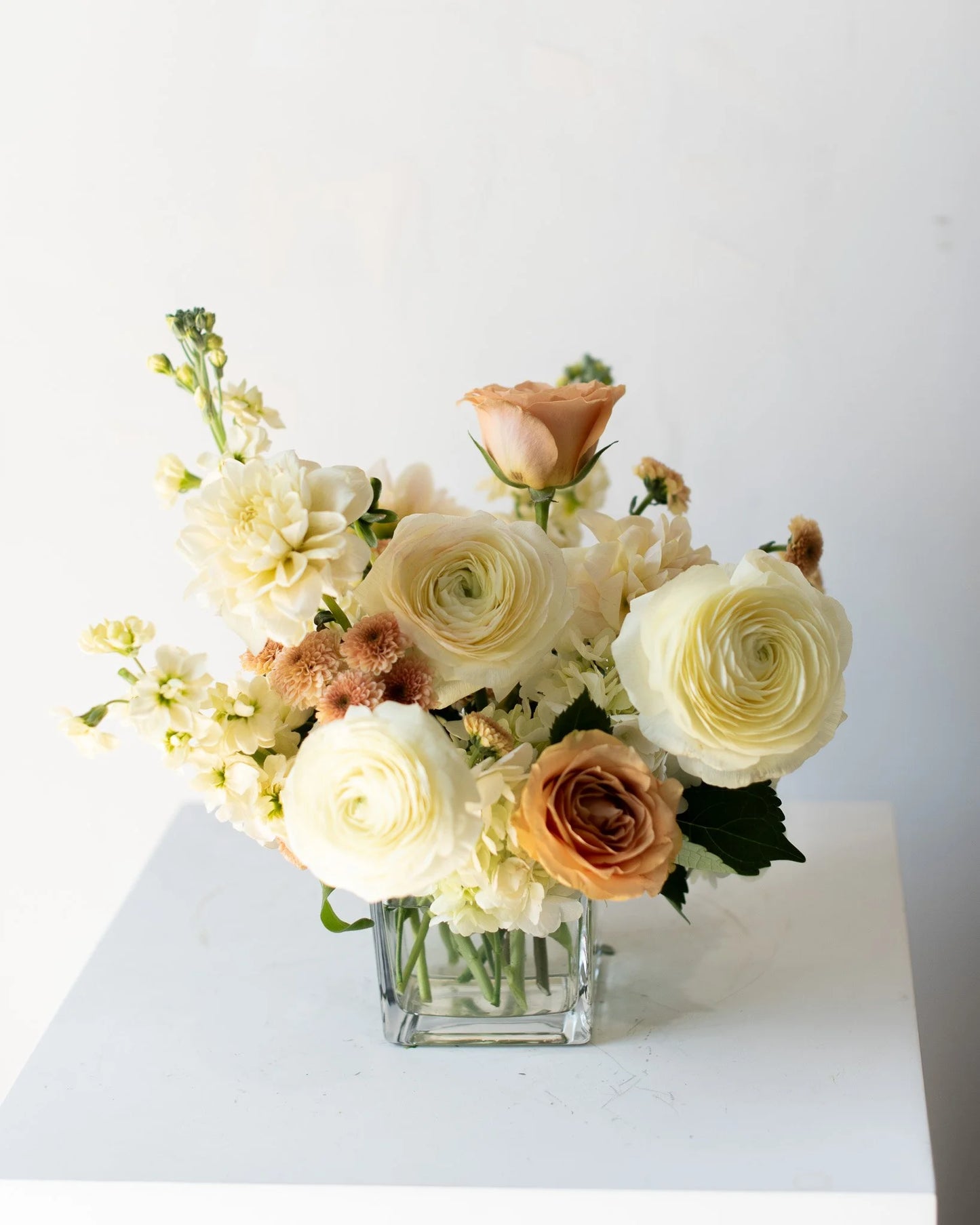 Modern cream and peach floral arrangement in glass vase by Annam Studio, Toronto