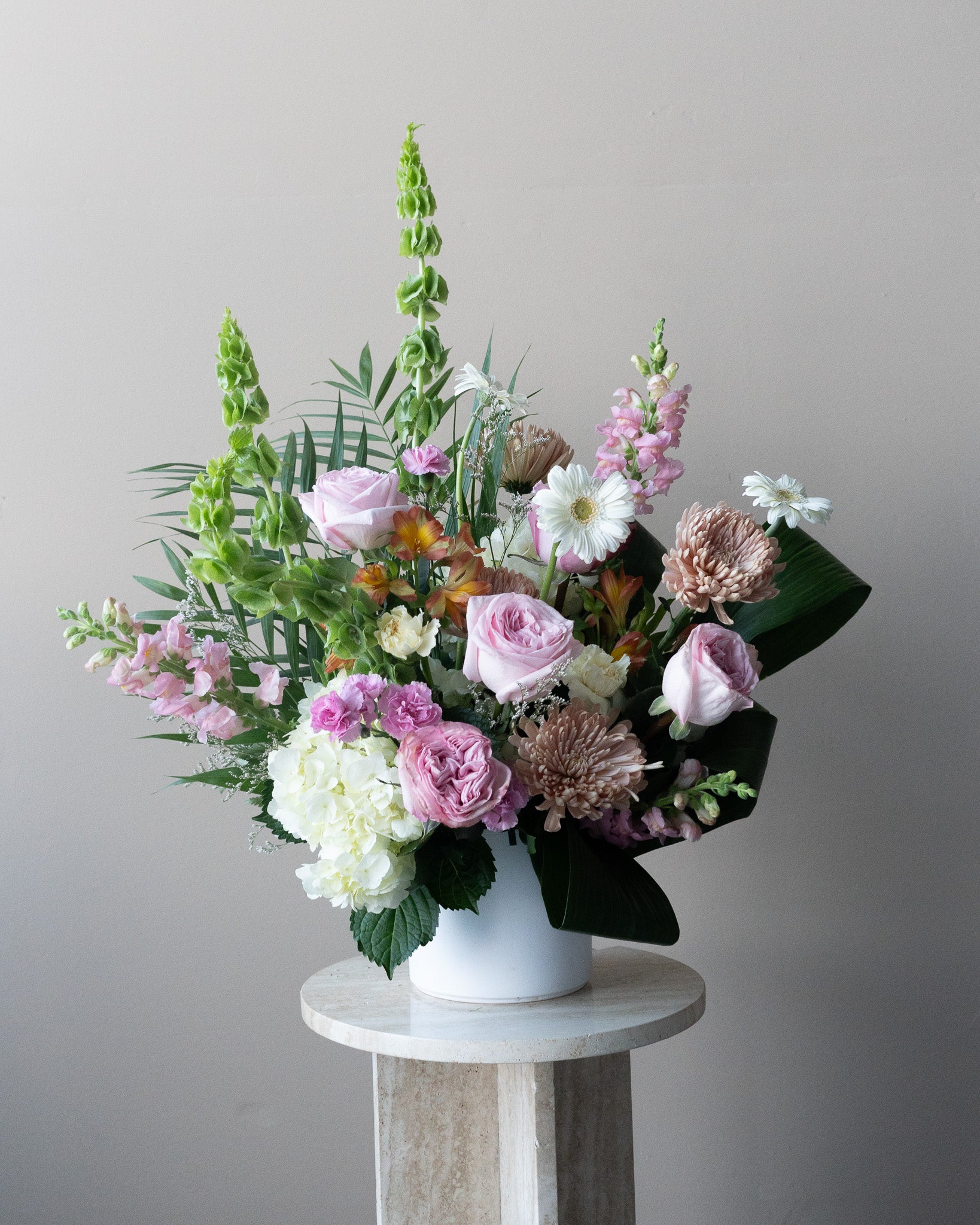 Soft pink and green tribute floral arrangement for funerals or remembering a loved one. Delivery in Toronto