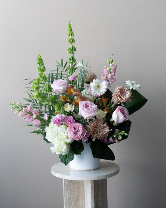 Soft pink and green tribute floral arrangement for funerals or remembering a loved one. Delivery in Toronto