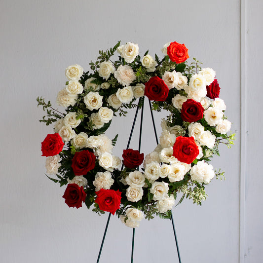 Red and white rose wreath on stand by Annam Studio, Toronto floral arrangement.