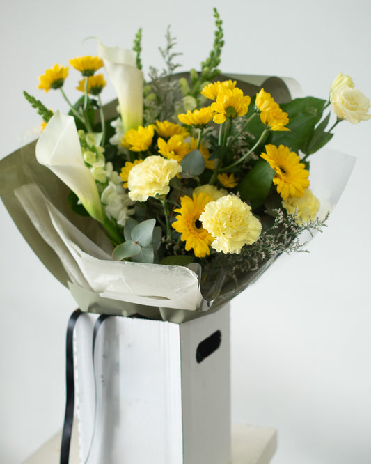 Bouquet of yellow and white flowers with greenery for delivery or pickup in Toronto.