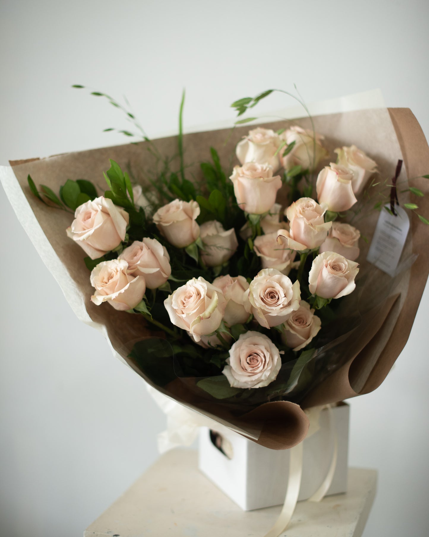 Bouquet of light pink roses wrapped in brown paper for delivery or pickup in Toronto.
