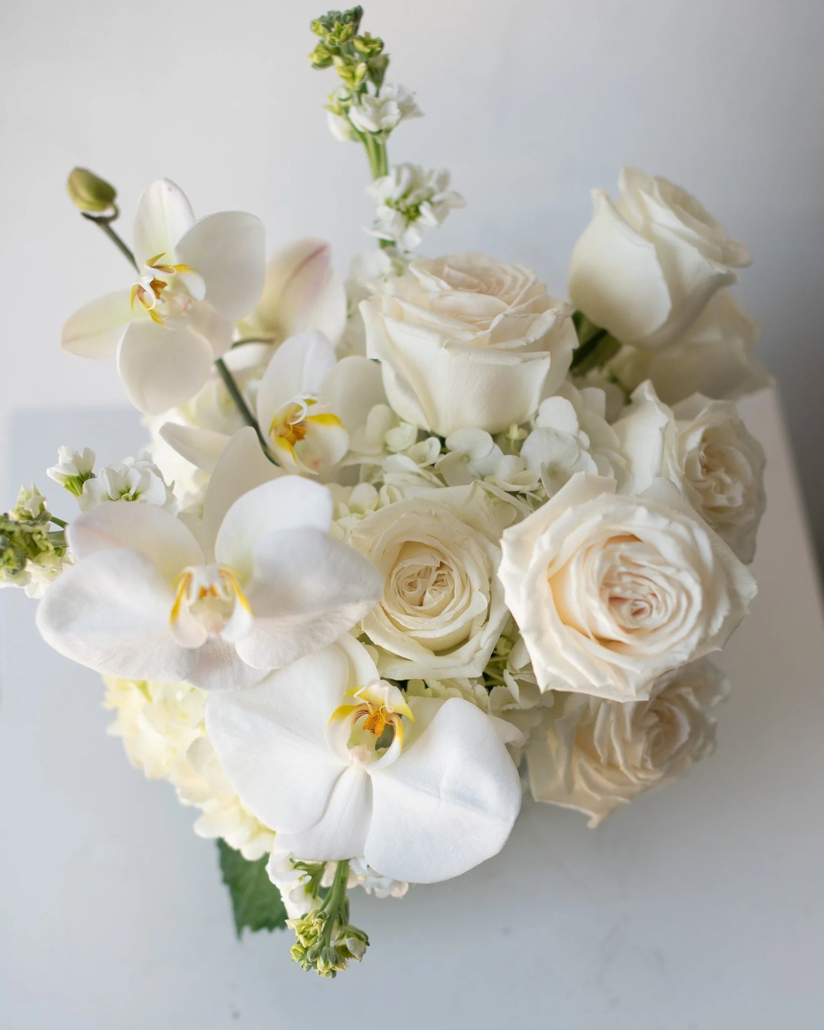 Modern white floral arrangement with roses and orchids by Annam Studio Toronto