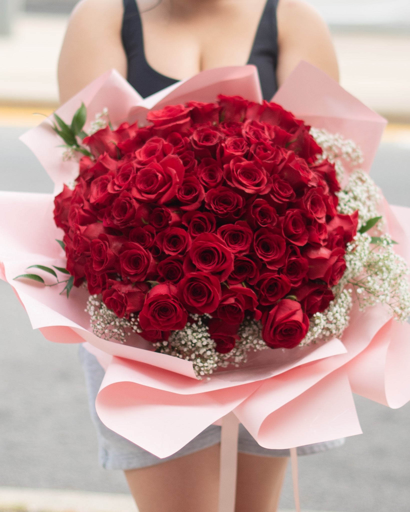 Bouquet of 100 red roses with babies breath and greenery for delivery or pickup in Toronto.
