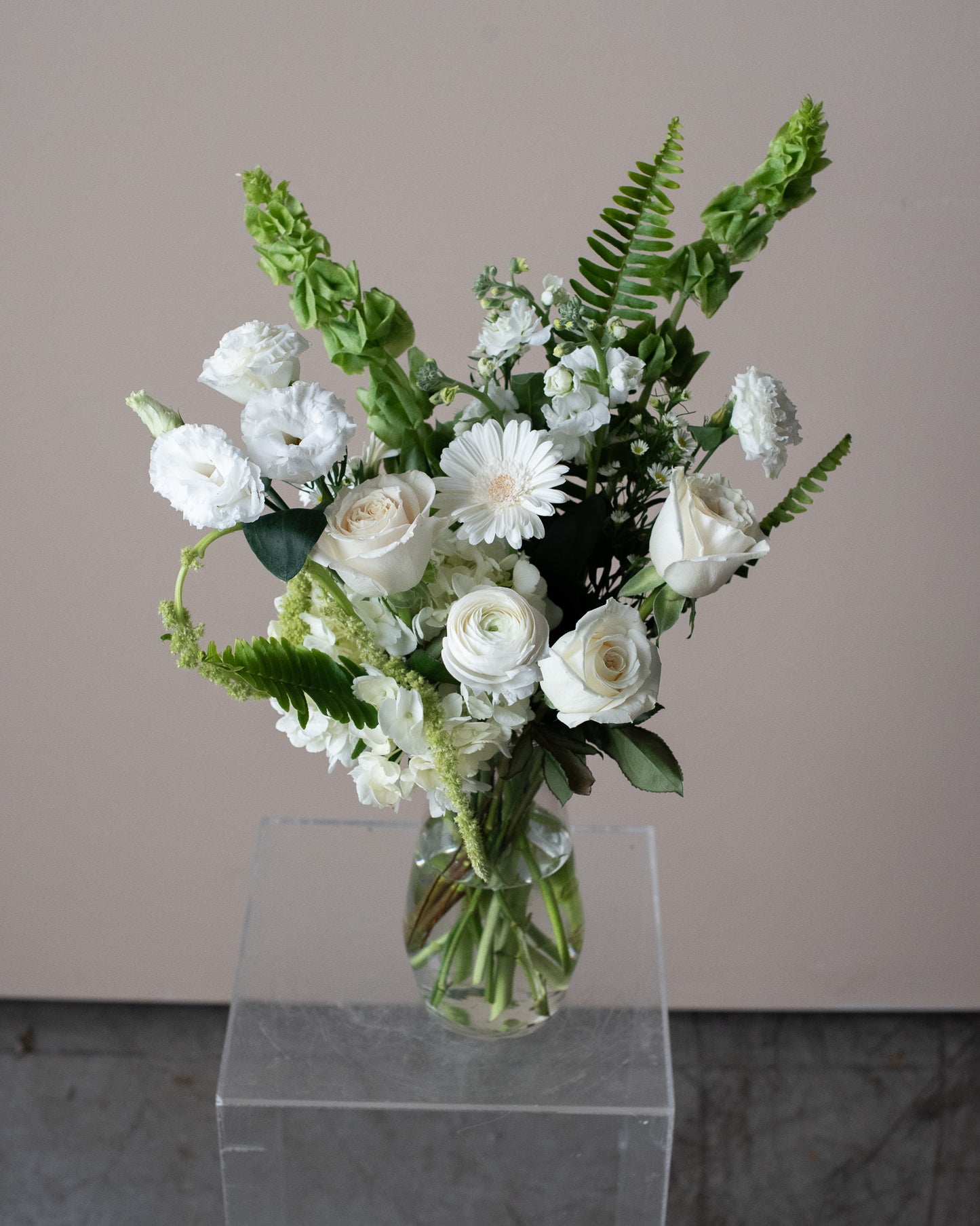 Bouquet of white flowers with greenery in a clear vase for delivery or pickup in Toronto.