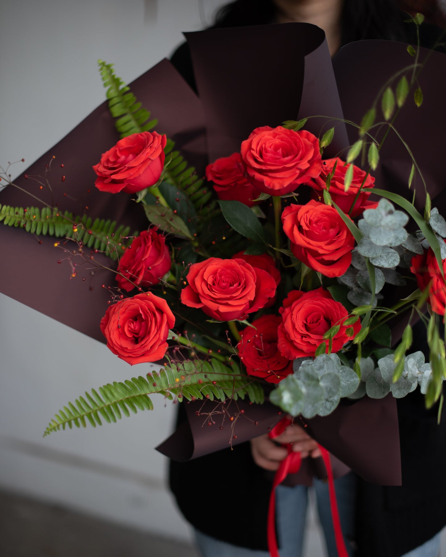 Hand-tied bouquet of red roses, greenery and brown wrap from Annam Studio Toronto floral shop