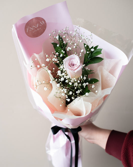 A single rose with greenery wrapped in cellophane and a Korean wrap for delivery or pickup in Toronto.