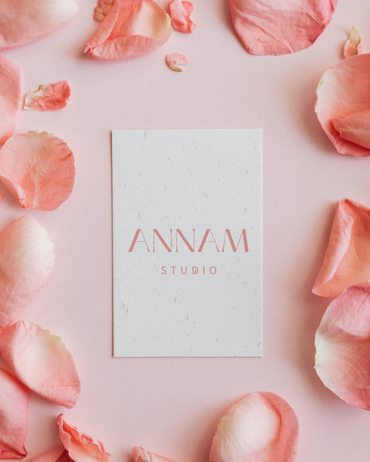 Annam Studio card on pink background with rose petals, Toronto floral arrangement branding